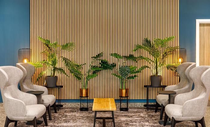 Hotel lobby with chairs, foliage and lanterns